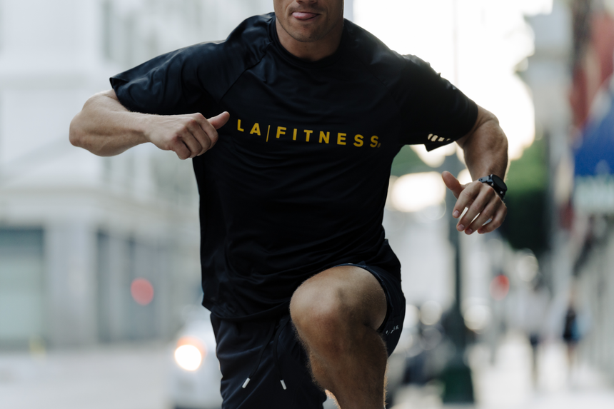 Men’s black S/S Raglan Perforated Knit Tee with yellow text "LA | FITNESS"